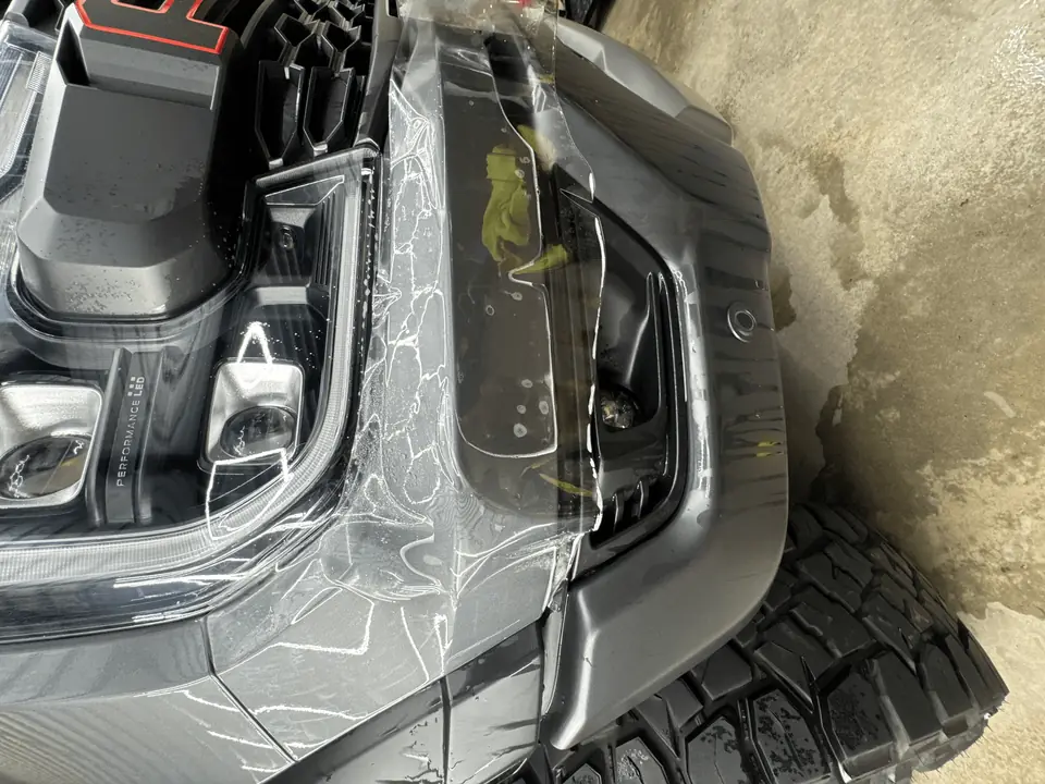 3M paint protection film being installed on a truck's front bumper and headlight at Texas Automotive Care Solutions in Boerne, TX